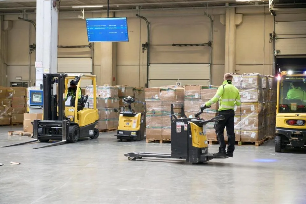 Customs officers inspecting parcels on a conveyor at the customs facility of Liège Airport, Belgium