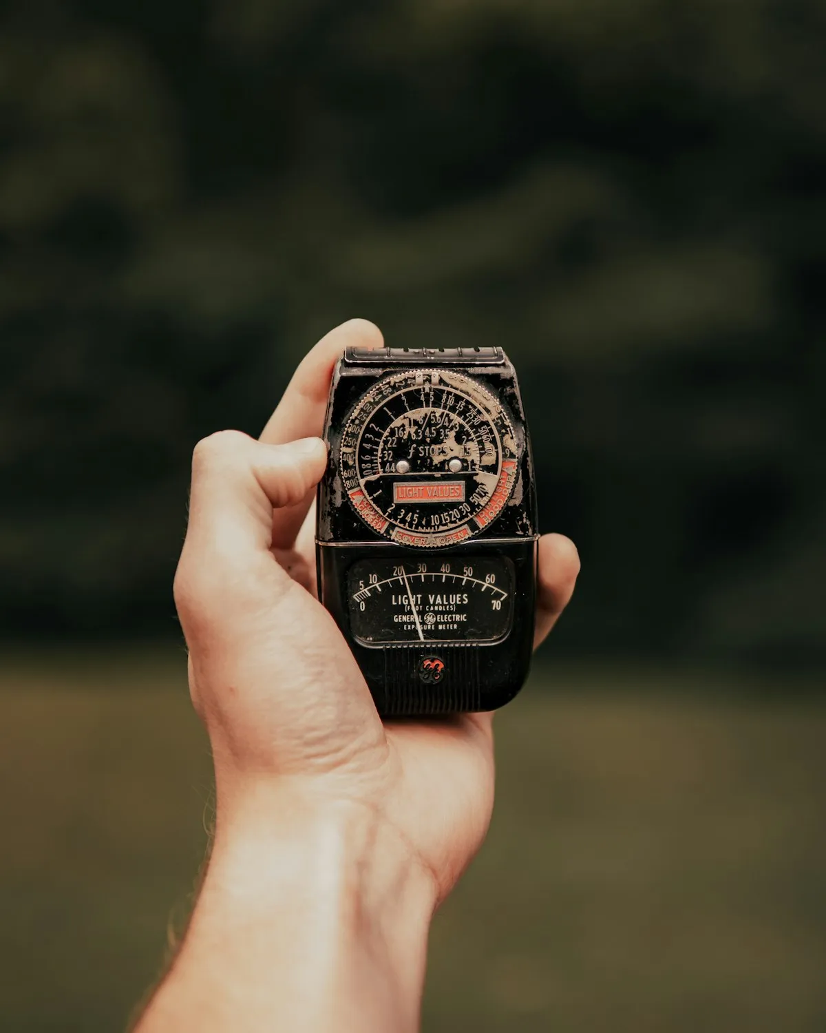 Hand holding a handheld light meter for film photography