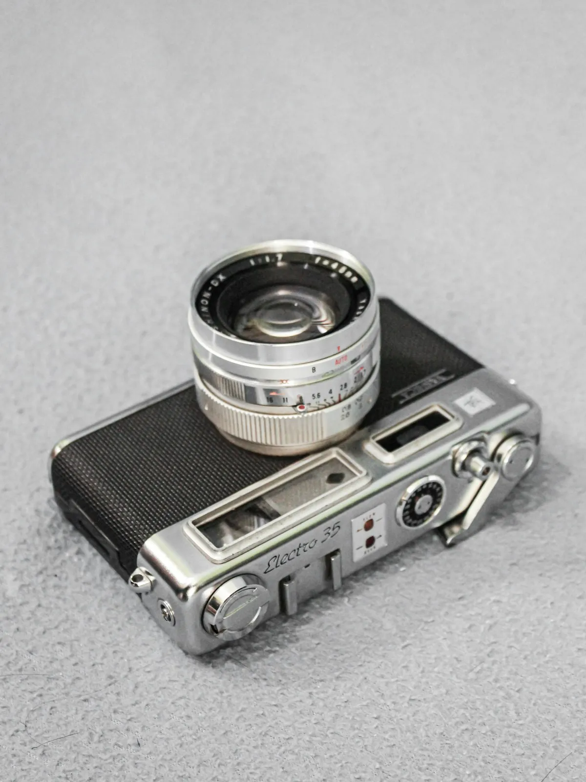 Film camera and digital camera side by side on a wooden desk